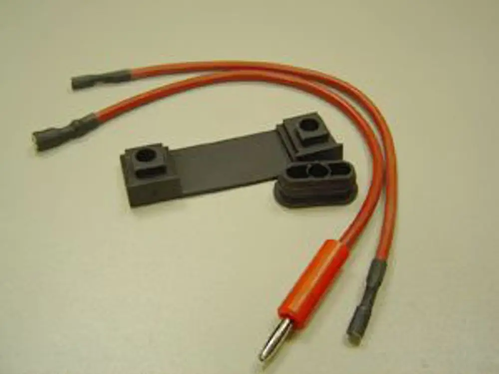 Zwei rote Kabel mit verschiedenen Anschlüssen und einer schwarzen Verbindungsfolie. Komponente von Remeha, vermutlich für Zünd- und Ionisationszwecke in Heizsystemen.